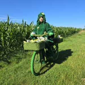 Gerda Gras –                                                                                                                        Grasdame auf Grasfahrrad